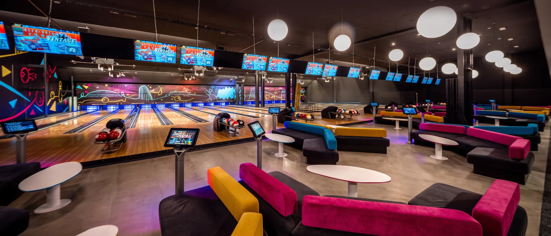 Bowling lanes and colorful lounge seating at a modern bowling venue