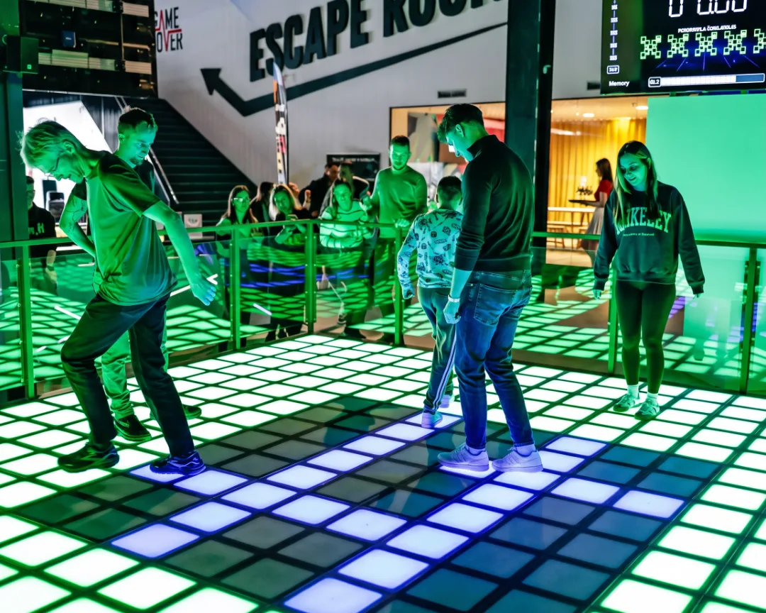 Guests playing on an interactive LED game floor at a family entertainment center